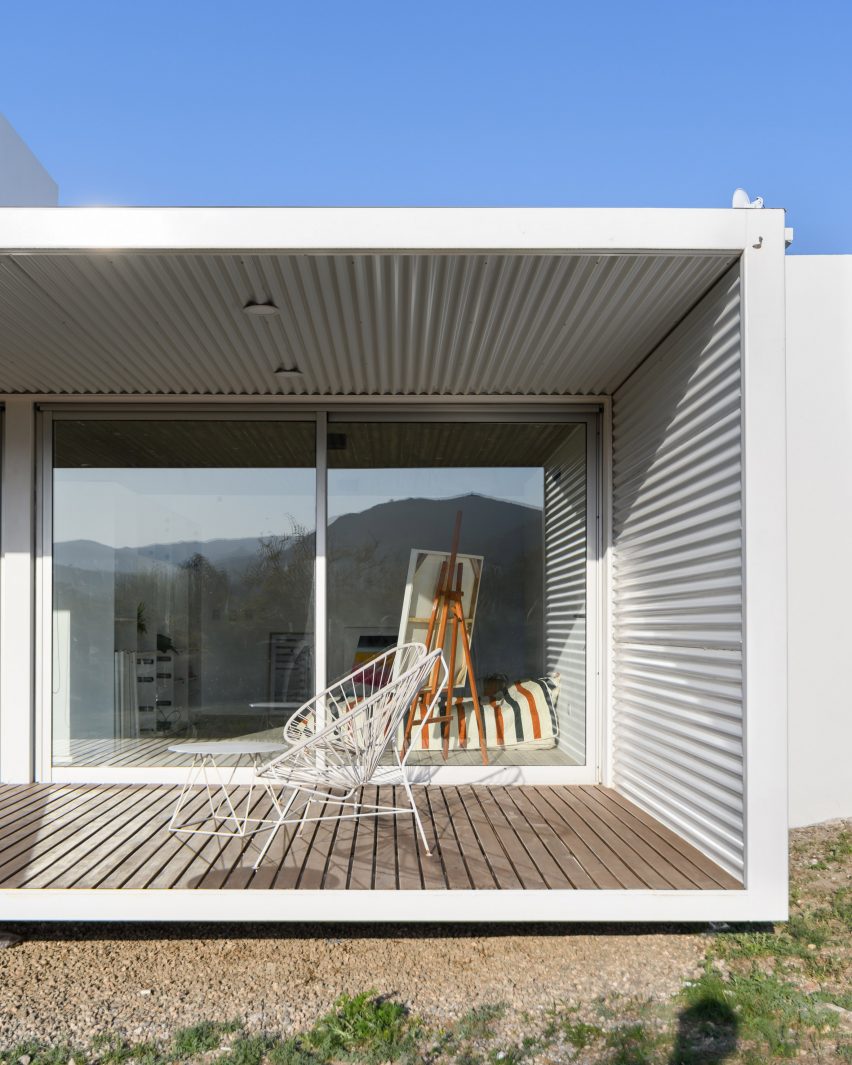 A chair on the veranda of a wihte house