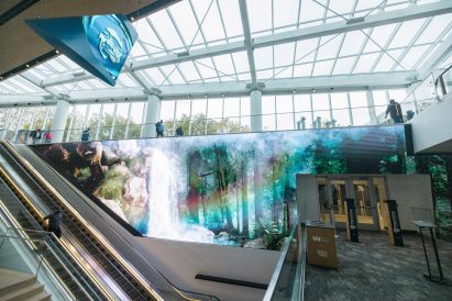 An elevator was placed beside a large screen 