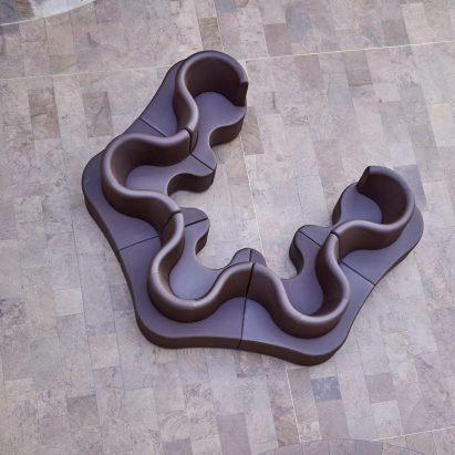 Photograph from above showing a purple undulating sofa in a large room