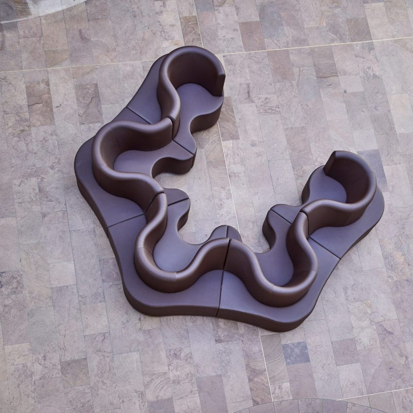 Photograph from above showing a purple undulating sofa in a large room