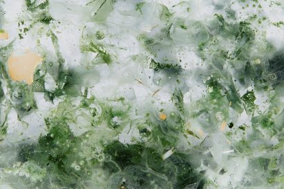 Close-up of green, white and gold glass tile with cloudy translucent background