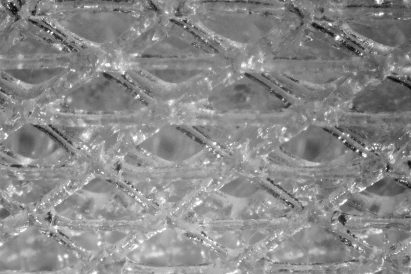 Head of the InstaSwab under a microscope showing the dense pattern of fibres