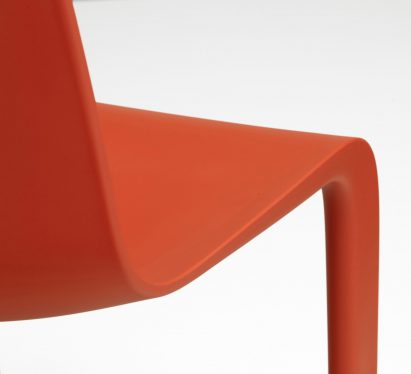 Close-up on the curved plastic shell seat of a red Evo-C chair