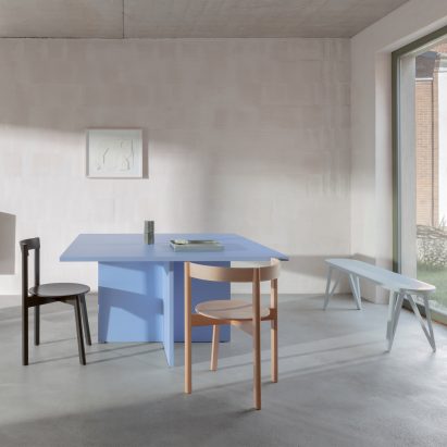A photograph of Jazz dining chairs around a blue table in a naturally lit room
