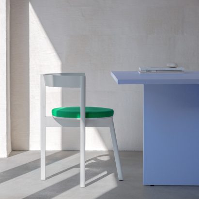 White and green Jazz dining chair by David and Julian Löhr for Loehr in front of a blue table