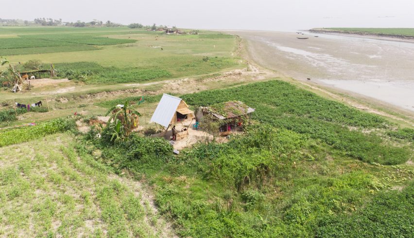 Bamboo house on stilts in the middle of a green field in a river delta