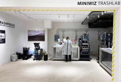 Person in lab coat sorting plastic waste in the Miniwiz Trashlab pop-up show in Sardinia