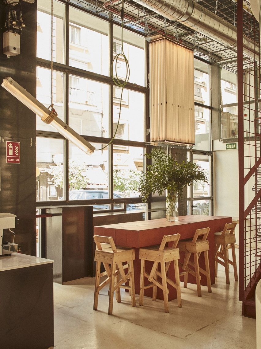 Interior of Mo de Movimiento restaurant with chandelier made of upcycled fluorescent lighting tubes hanging next to a long, high table