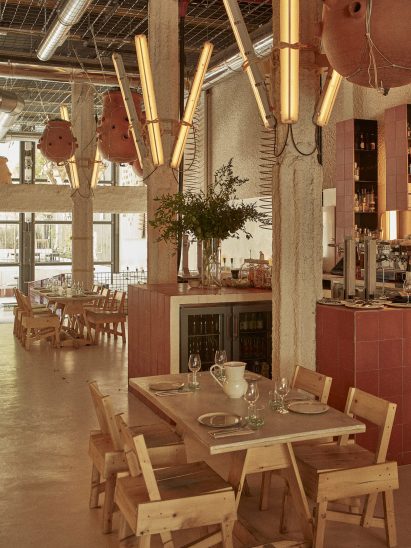 Inside the Mo de Movimiento restaurant with wooden furniture and lighting fixtures made from upcycled fluorescent light casing