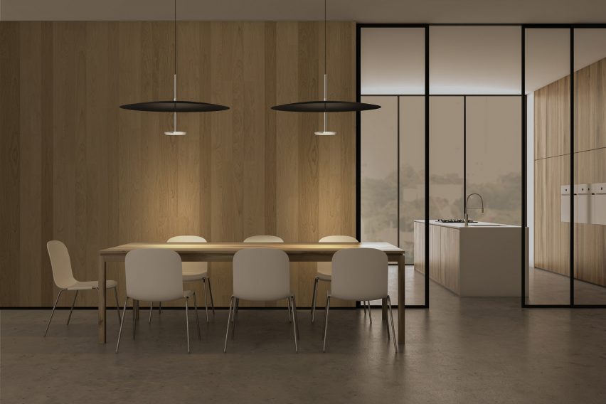 Pablo Design's Sky Dome pendant light dimly lit above a conference table in an office-like setting