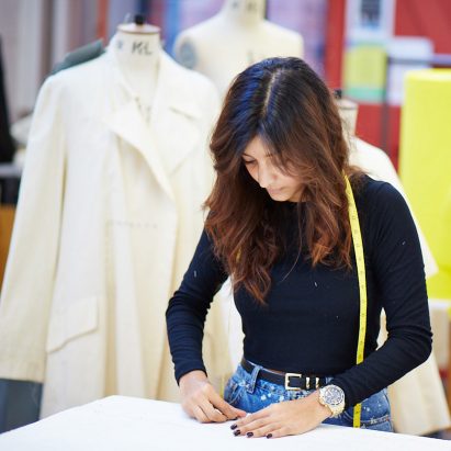 Student working on a workbench with mannequins behind
