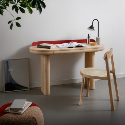 A photograph of a Brulla chair in natural ash situated at a desk