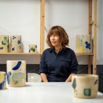 Ceramicist Ana Illueca in her studio next to colourful pottery