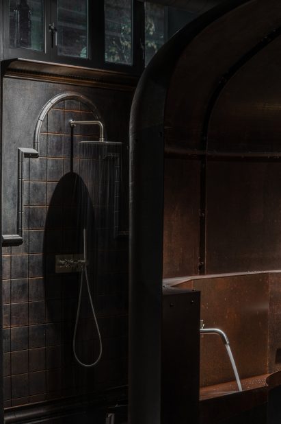 Cast-iron wall section with shower in retail interior by Holloway Li