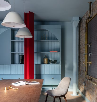 Coworking space with blue walls and red column in Boiler on ground floor of Coalbrook's London showroom