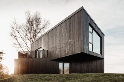 A black cabin in the countryside by Koto