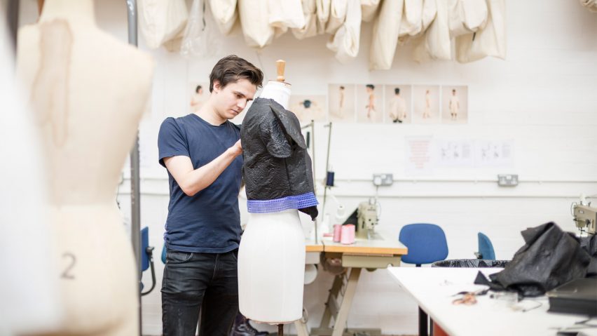 A photograoh of a student pinning fabric to a dressmakers' mannequin
