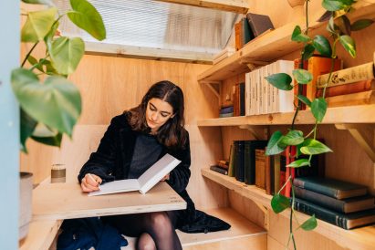 A woman journaling inside a library