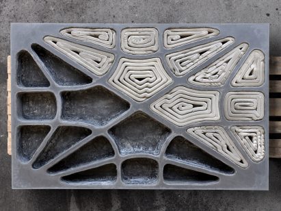 Overhead view of precast concrete slab with hollow cells, half filled with formwork half empty