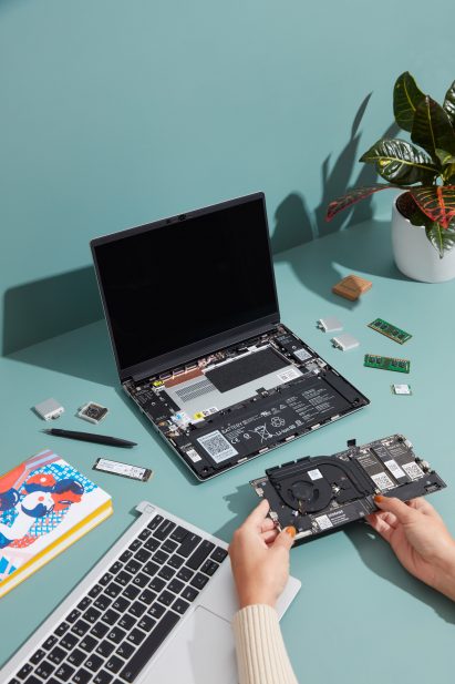 Hands holding the motherboard of the modular Framework laptop