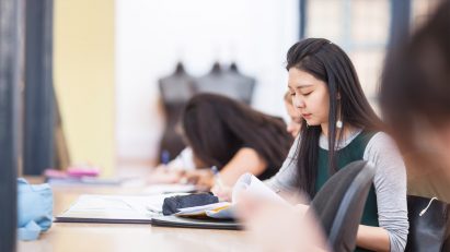 A photograph of a Global Fashion Management student studying at a desk