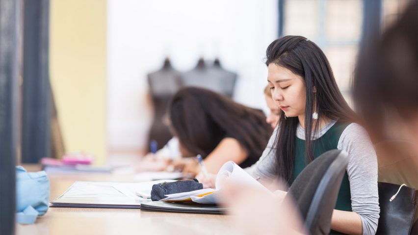 A photograph of a Global Fashion Management student studying at a desk