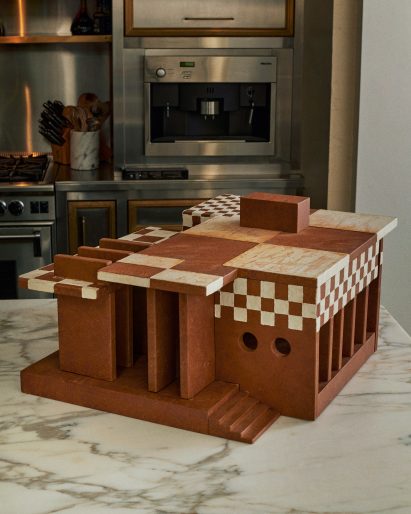 Side view of the Gingerbread Dreamhouse, showing two side porthole windows and a colonnade at the rear