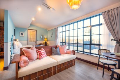 Hotel room with baby blue walls and wooden bench in foreground