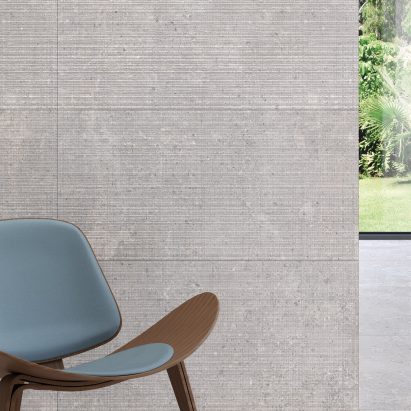 A photograph of Omina tiles used on a wall with a blue chair in front