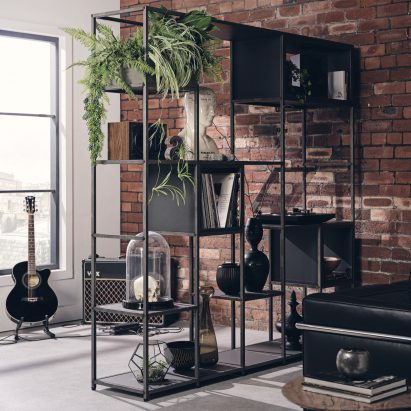 A photograph of Shelved Modular Furniture, which was presented on Dezeen Showroom, used in a living room as a room separator