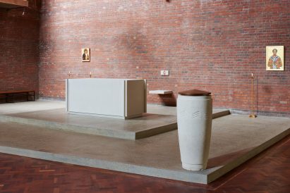 St John Chrysostom church font made of Portland limestone with matching altar behind it
