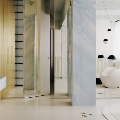 White armchair under spherical pendant lights in interior of The Whale apartment in Paris designed by Clément Lesnoff-Rocard