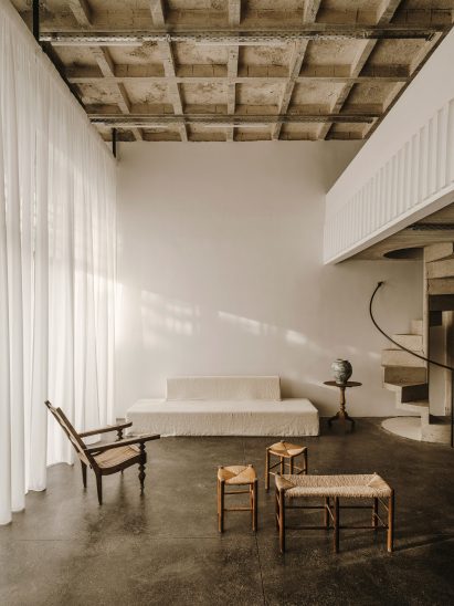 White sofa next to vintage wicker and wood seating in 10AM Lofts event space