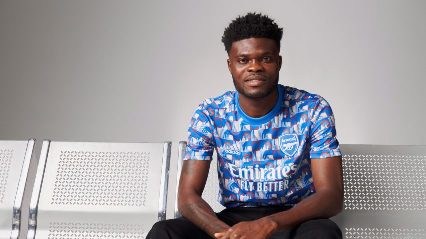 A footballer wearing a blue Arsenal football t-shirt