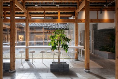 White counter and stool seating around % Arabica cafe in Kuanzhai Alley by Blue Architecture Studio
