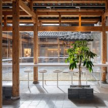 White counter and stool seating around % Arabica cafe in Kuanzhai Alley by Blue Architecture Studio
