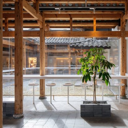 White counter and stool seating around % Arabica cafe in Kuanzhai Alley by Blue Architecture Studio