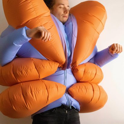 Man wearing the Stress Suit project, an inflated blue and orange body suit, completed on the Design Investigations course