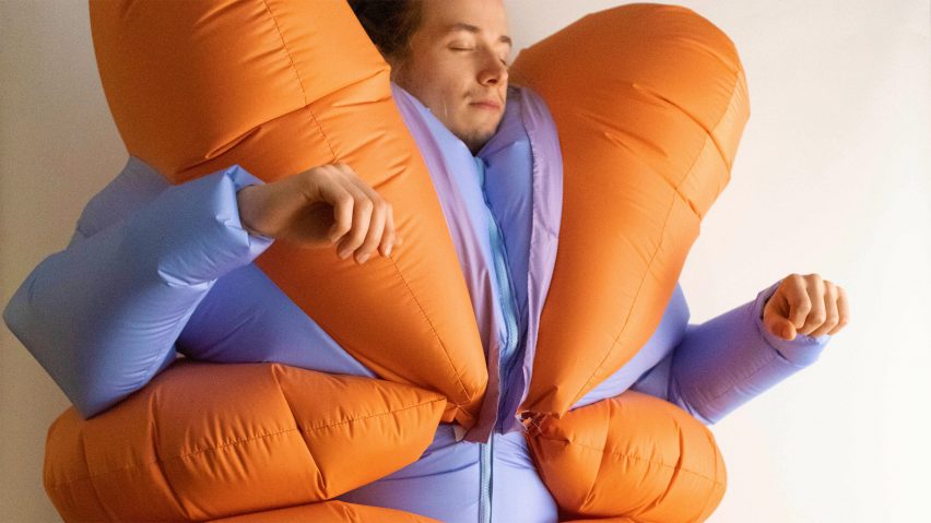 Man wearing the Stress Suit project, an inflated blue and orange body suit, completed on the Design Investigations course