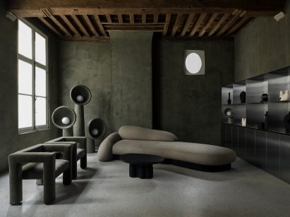 Green lamps and chairs by Faina alongside beige sofa and steel storage unit in Faina Gallery