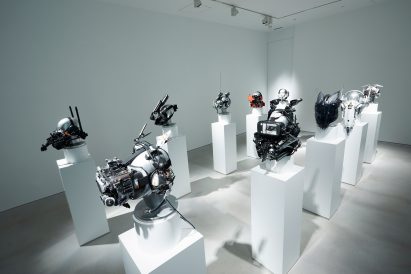 Gallery space with a series of cyberpunk masks positioned on plinths