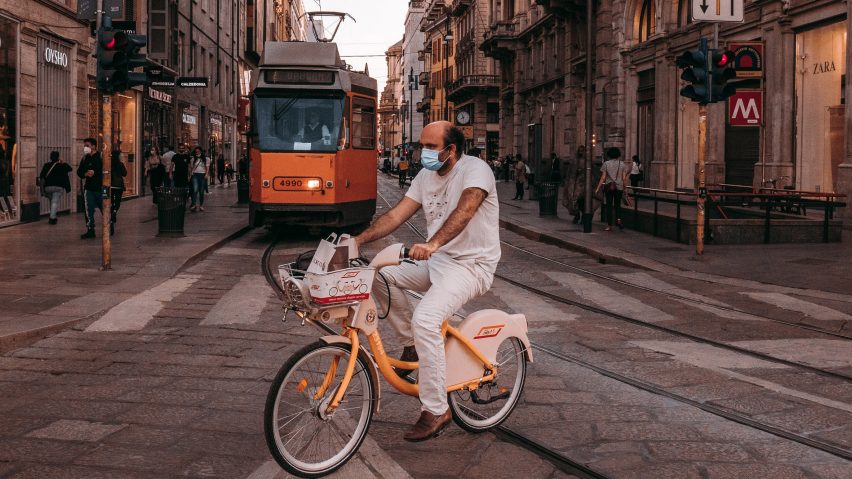 Man cycling in front of a tram in Milan, illustrating a news story about the planned Cambio cycling network in Milan