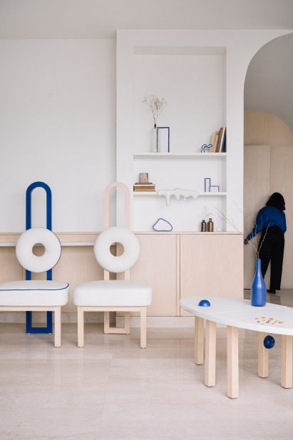 Matching chairs in cobalt-blue and nattural wood with circular cushions in living room of Out of the Blue apartment