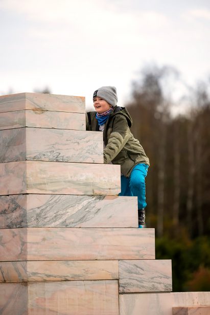 A child climbing a marble sculpture