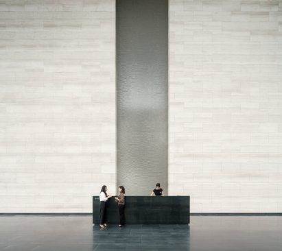 Tall water feature and textured stone walls in Shenzhen's Rural Commercial Bank building