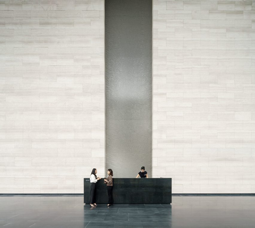Tall water feature and textured stone walls in Shenzhen's Rural Commercial Bank building