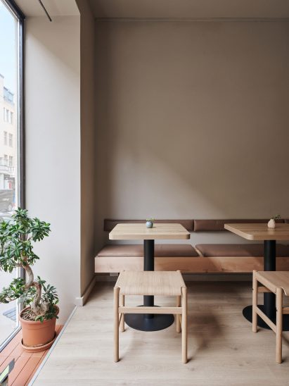 Seating area of teahouse designed by Yatofu with oak bench, table and low stool