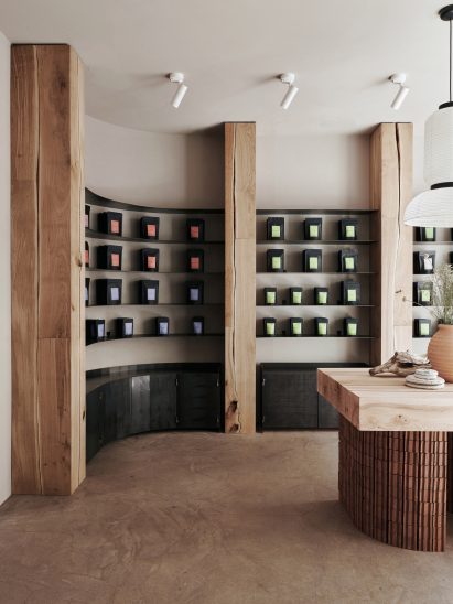 Teas in black bags displayed on wall of curved shelving made of oak and oxidised steel in Teemaa Helsinki