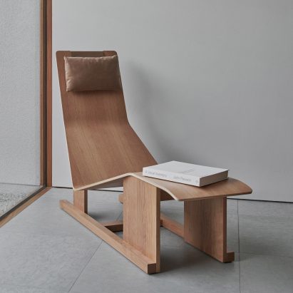 Wooden 4PM chaise lounge by Massproductions in a concrete room