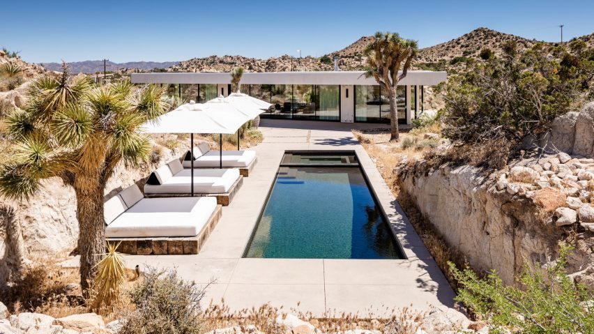 A Plum Guide holiday villa with a pool, sun loungers and parasols